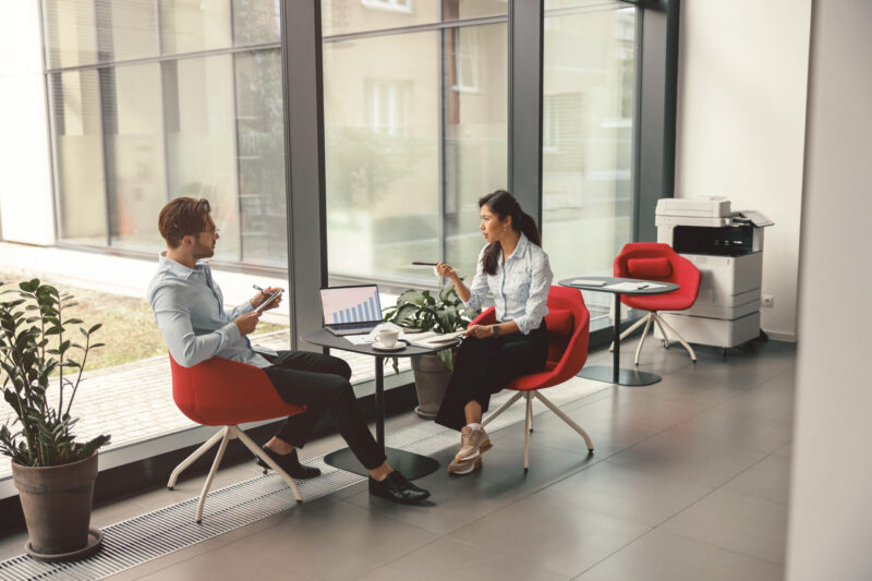 Two business colleagues working with documents together sitting in office.High quality photo